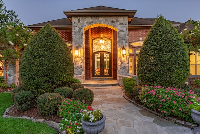 exterior entry at dusk featuring french doors