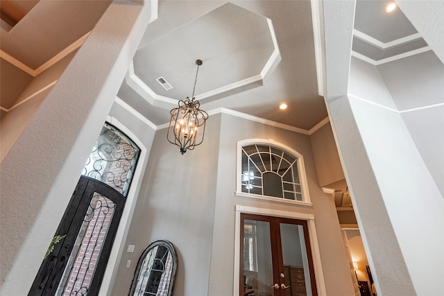 interior space featuring a high ceiling, an inviting chandelier, and ornamental molding