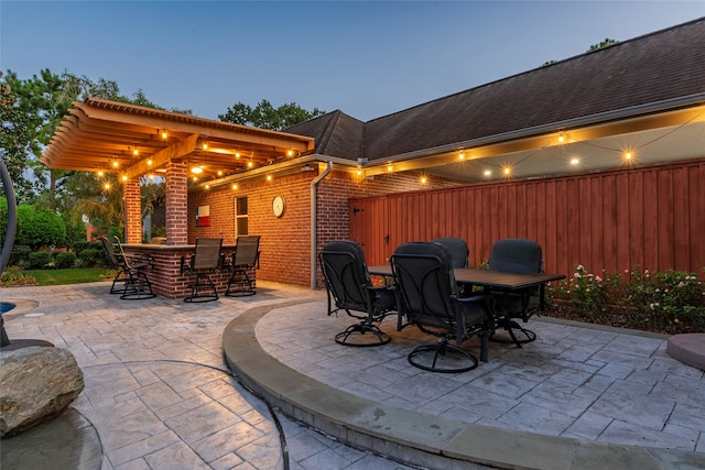 patio terrace at dusk featuring an outdoor bar