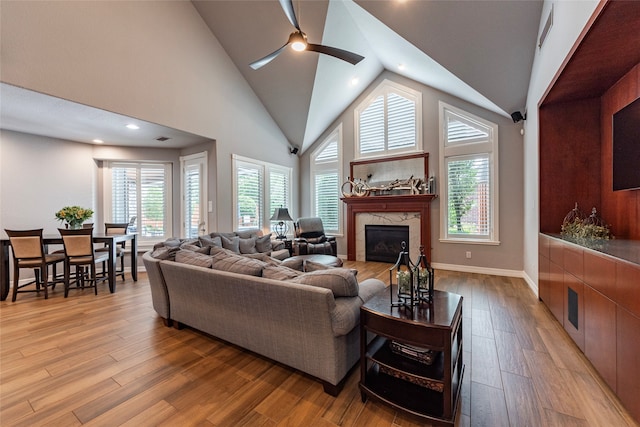 living room featuring ceiling fan, a fireplace, plenty of natural light, and wood-type flooring