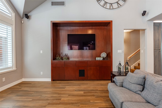 living room featuring light wood-type flooring and lofted ceiling