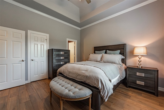 bedroom featuring crown molding, ceiling fan, a raised ceiling, and hardwood / wood-style floors