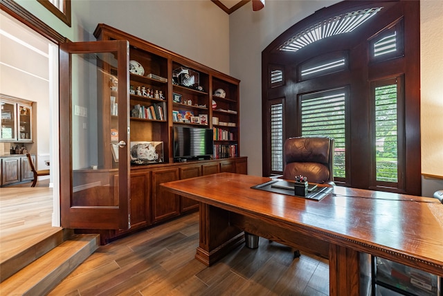 office area featuring a towering ceiling and dark hardwood / wood-style floors