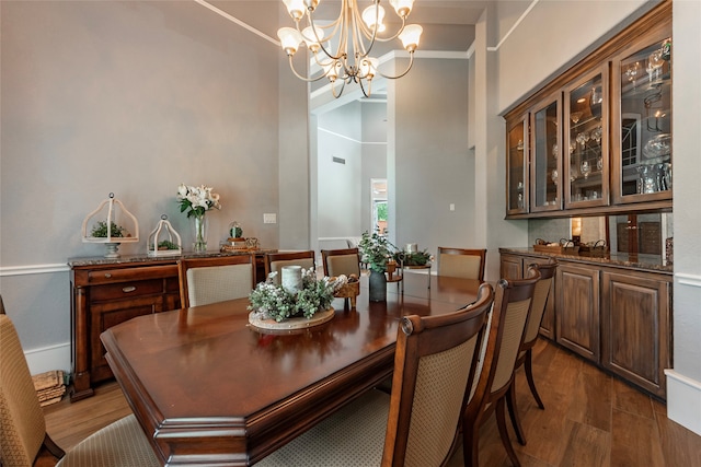 dining area with a notable chandelier, hardwood / wood-style floors, and high vaulted ceiling