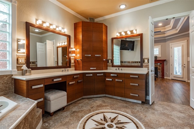 bathroom featuring a wealth of natural light, vanity, wood-type flooring, and a relaxing tiled tub