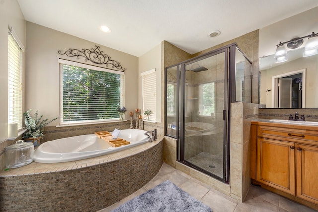 bathroom featuring tile patterned floors, vanity, a bath, and a shower stall