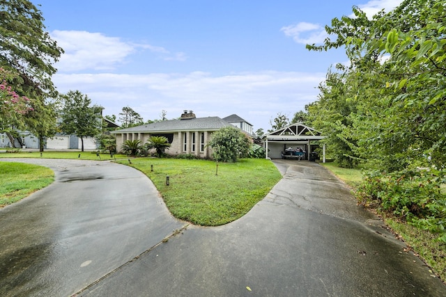 view of front facade featuring a carport, a front yard, and driveway