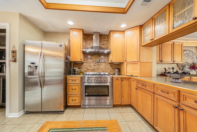 kitchen with light tile patterned floors, stainless steel appliances, visible vents, light countertops, and wall chimney range hood