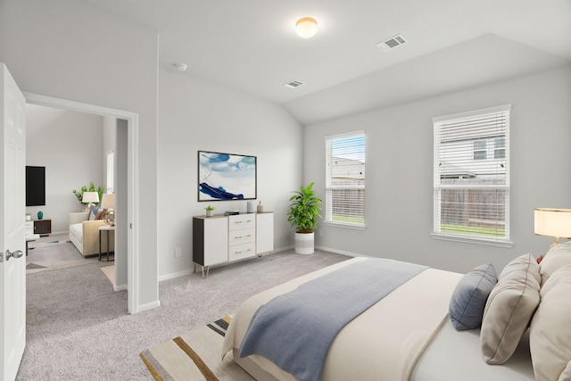 bedroom with light colored carpet and vaulted ceiling