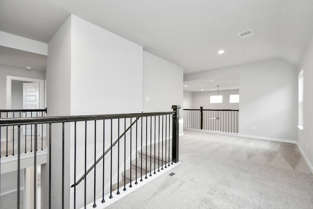 hall featuring lofted ceiling and carpet floors