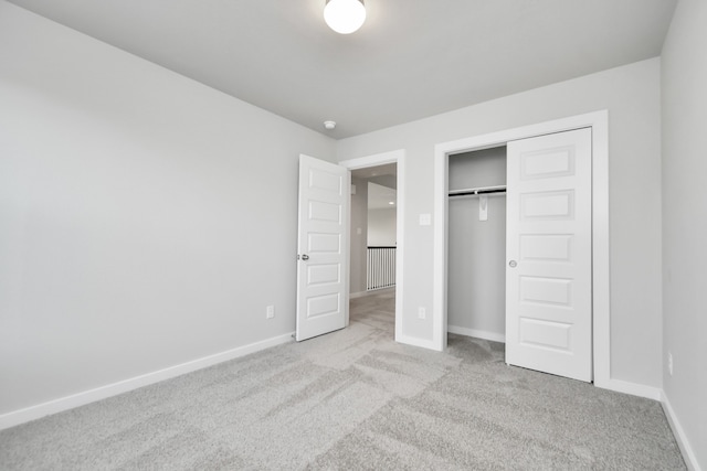 unfurnished bedroom featuring a closet and light carpet