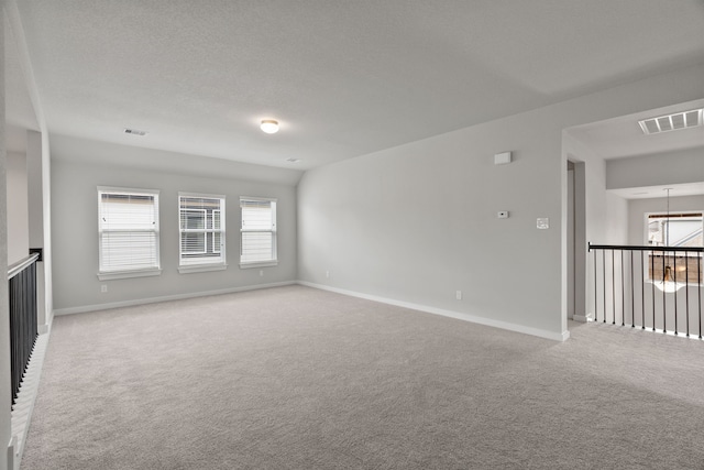 spare room with light colored carpet and lofted ceiling