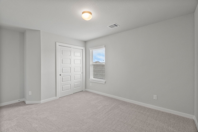 unfurnished bedroom with a closet and light carpet