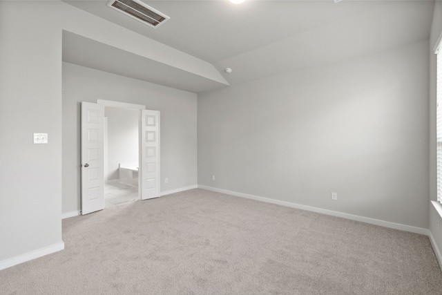 carpeted spare room featuring lofted ceiling