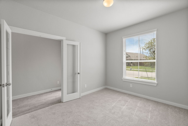 carpeted empty room featuring french doors