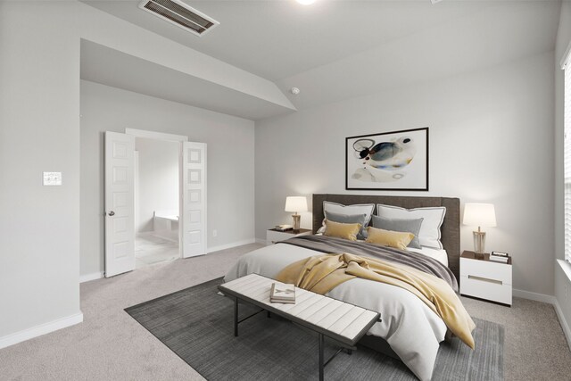 carpeted bedroom featuring lofted ceiling and ensuite bathroom