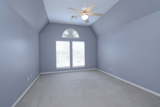 additional living space with vaulted ceiling, ceiling fan, a healthy amount of sunlight, and light carpet