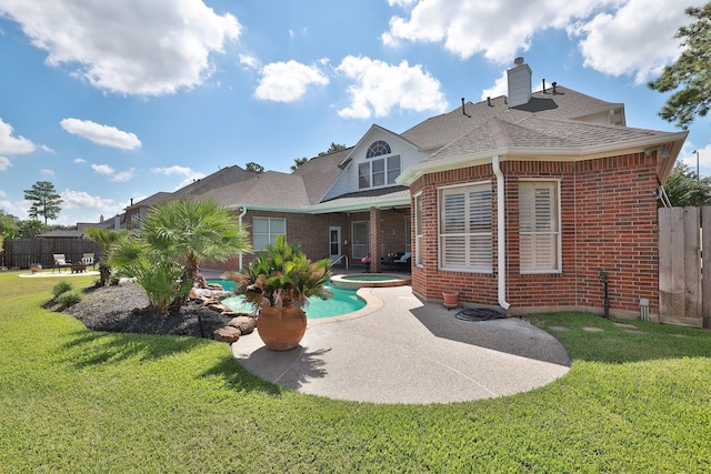 rear view of house featuring fence, a patio, an in ground hot tub, and brick siding