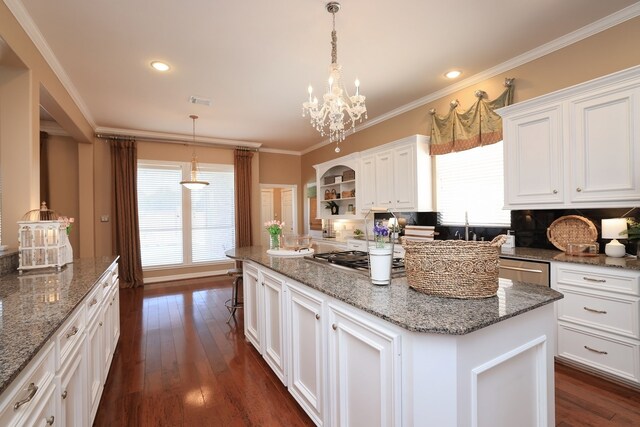 kitchen with a center island, stainless steel gas cooktop, white cabinetry, and a wealth of natural light
