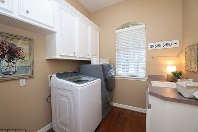 clothes washing area with cabinet space, dark wood-style flooring, a sink, separate washer and dryer, and baseboards