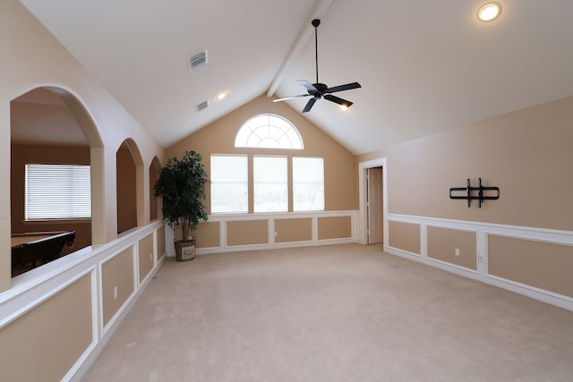 empty room featuring visible vents, lofted ceiling with beams, ceiling fan, and light colored carpet
