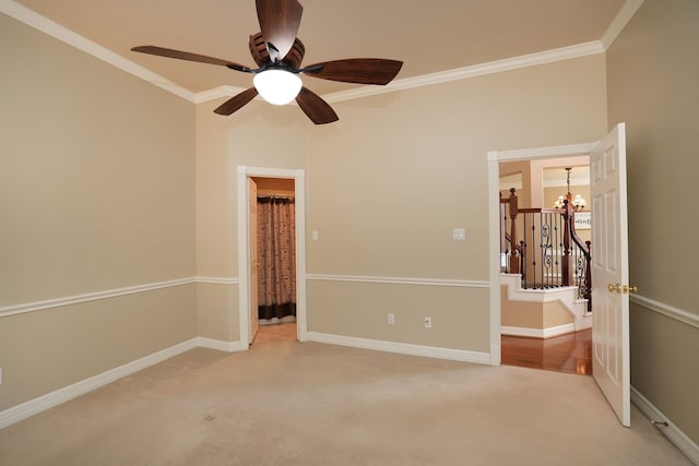 spare room featuring baseboards, light colored carpet, ornamental molding, and ceiling fan with notable chandelier