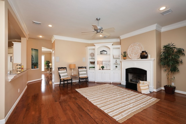 living room featuring ceiling fan, visible vents, a fireplace with flush hearth, crown molding, and dark wood-type flooring