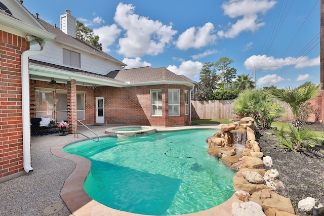view of swimming pool featuring a patio, fence, and a pool with connected hot tub
