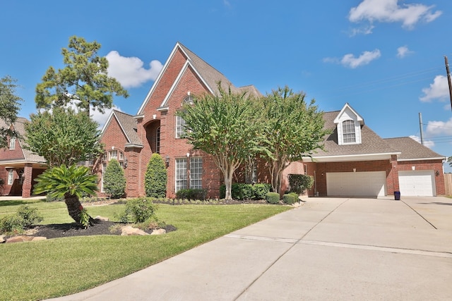 traditional home featuring brick siding, an attached garage, driveway, and a front yard