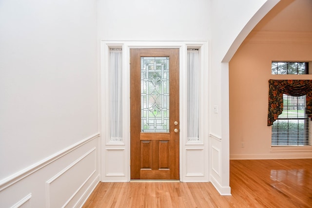 foyer entrance with plenty of natural light, light hardwood / wood-style floors, and ornamental molding