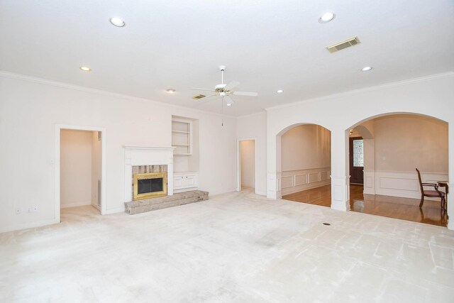 unfurnished living room featuring crown molding, light colored carpet, and ceiling fan