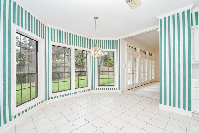 unfurnished dining area with a notable chandelier, plenty of natural light, and crown molding