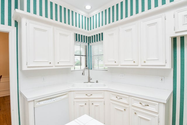 kitchen featuring dishwasher, backsplash, sink, and white cabinets