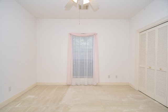 unfurnished bedroom with a closet, ceiling fan, and light carpet