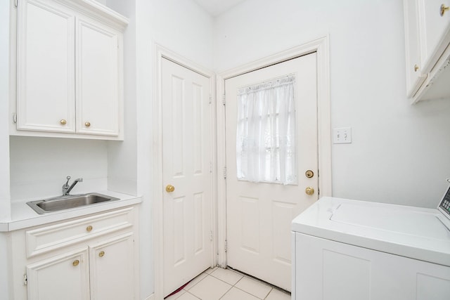 clothes washing area with washer / dryer, light tile patterned floors, cabinets, and sink