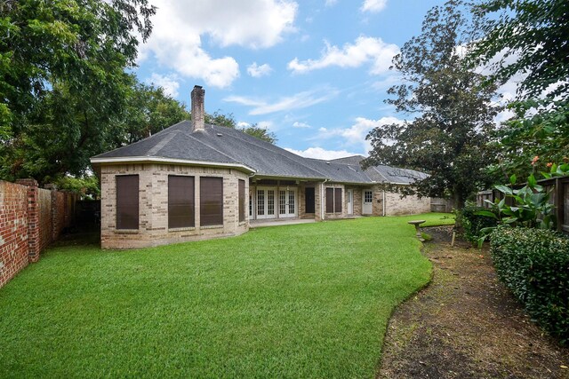 rear view of house featuring a lawn