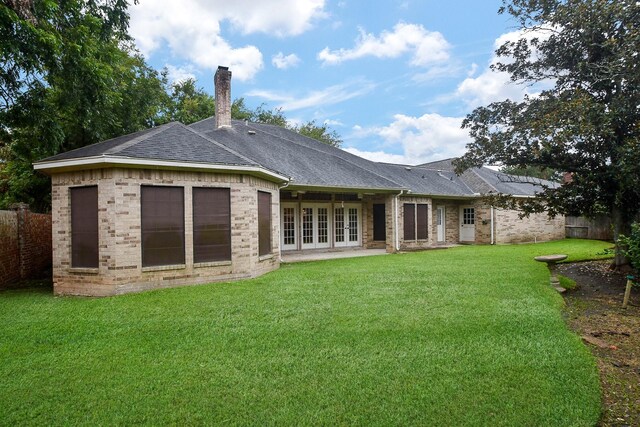 rear view of house featuring a yard and french doors