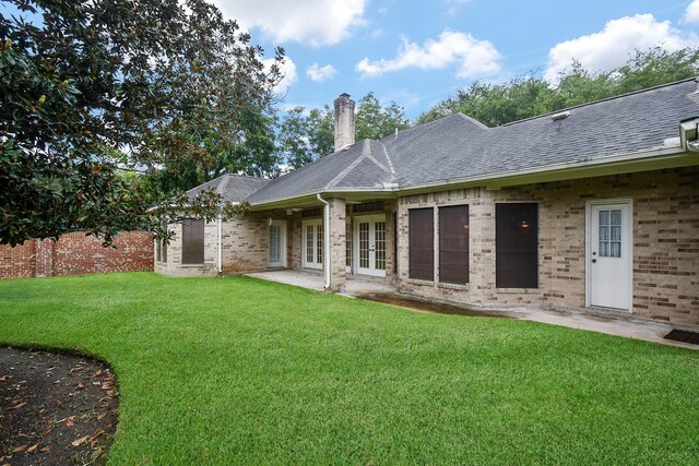 rear view of property featuring a yard and a patio area