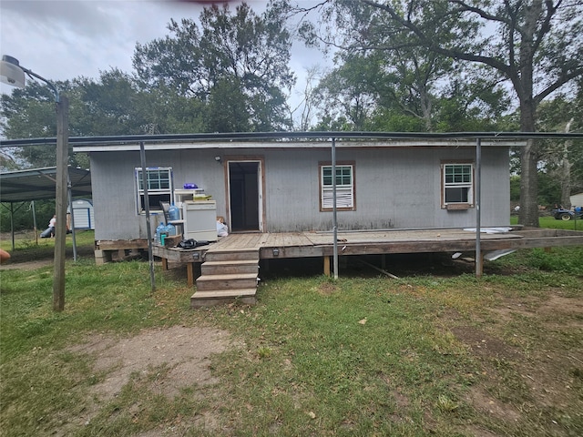 rear view of house featuring a lawn and a carport