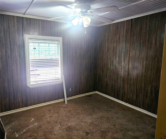 carpeted spare room with wood walls and ceiling fan