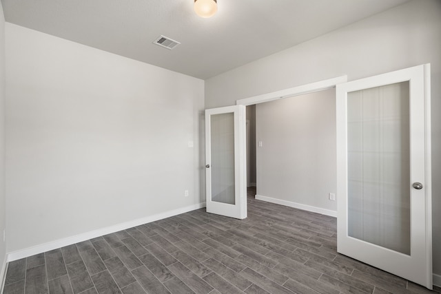 unfurnished bedroom with dark hardwood / wood-style flooring and french doors