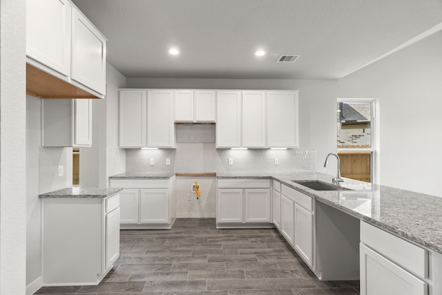 8427 Northern Pintail Dr, Houston, TX 77049 - kitchen featuring visible vents, a sink, tasteful backsplash, and light stone counters