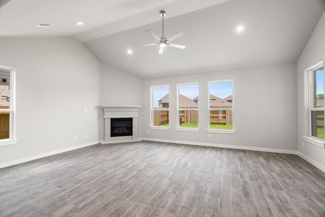 8427 Northern Pintail Dr, Houston, TX 77049 - unfurnished living room with wood finished floors, a glass covered fireplace, lofted ceiling, baseboards, and ceiling fan