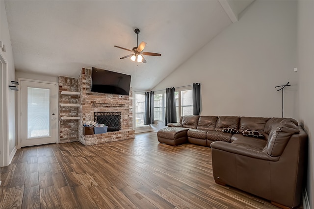 living room with ceiling fan, high vaulted ceiling, hardwood / wood-style flooring, and a brick fireplace