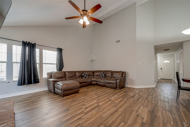 living room with a textured ceiling, high vaulted ceiling, hardwood / wood-style floors, and ceiling fan