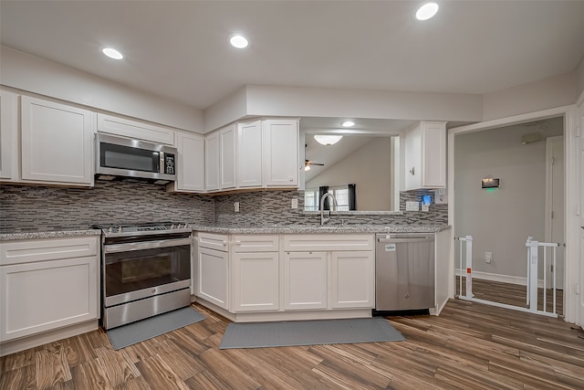 kitchen with white cabinetry, stainless steel appliances, sink, and decorative backsplash