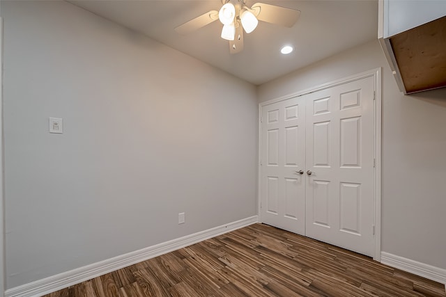 unfurnished bedroom featuring dark wood-type flooring, ceiling fan, and a closet