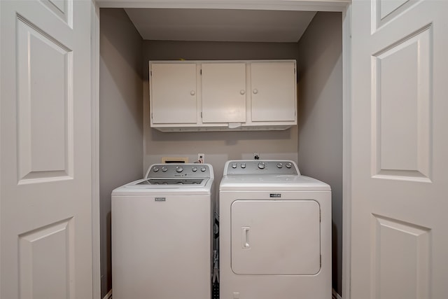 laundry area featuring washing machine and dryer and cabinets