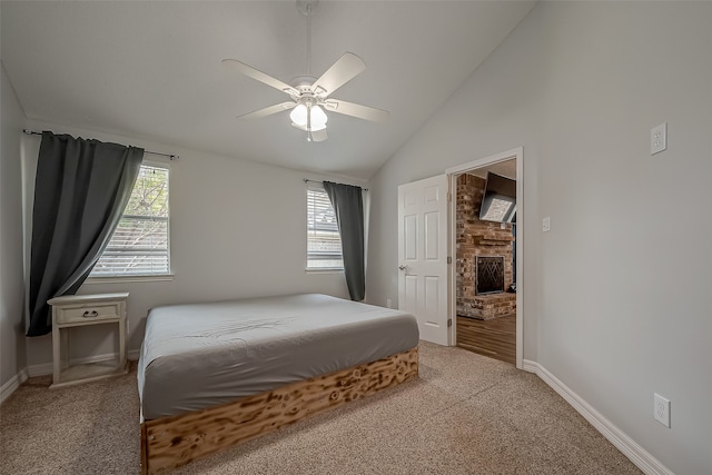 bedroom with high vaulted ceiling, ceiling fan, light colored carpet, and a fireplace