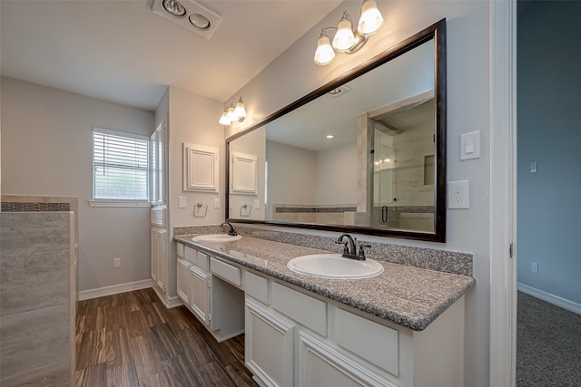 bathroom featuring hardwood / wood-style floors, a shower with door, and vanity